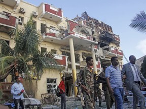 Security forces and others walk in front of the damaged Hayat Hotel in the capital Mogadishu, Somalia Sunday, Aug. 21, 2022. Somali authorities on Sunday ended a deadly attack in which at least 20 people were killed and many others wounded when gunmen from the Islamic extremist group al-Shabab, which has ties with al-Qaida, stormed the Hayat Hotel in the capital on Friday evening.