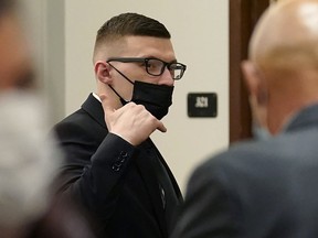 Volodymyr Zhukovskyy, of West Springfield, Mass., charged with negligent homicide in the deaths of seven motorcycle club members in a 2019 crash, raises his hand while departing a courtroom at Coos County Superior Court in Lancaster, N.H., Tuesday, July 26, 2022. Zhukovskyy has pleaded not guilty to multiple counts of negligent homicide, manslaughter, reckless conduct and driving under the influence in the June 21, 2019, crash.