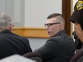 FILE - Volodymyr Zhukovskyy, of West Springfield, Mass., center right, charged with negligent homicide in the deaths of seven motorcycle club members in a 2019 crash, speaks with defense attorney Steve Mirkin, left, at Coos County Superior Court, in Lancaster, N.H., Monday, July 25, 2022.  The prosecution has rested Zhukovskyy's case on Wednesday, Aug. 3.  He faces negligent homicide and other charges in connection with the June 2019 crash in Randolph, New Hampshire