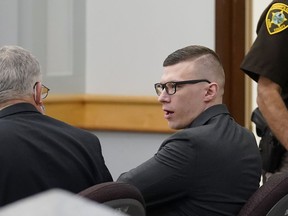 FILE - Volodymyr Zhukovskyy, of West Springfield, Mass., center right, charged with negligent homicide in the deaths of seven motorcycle club members in a 2019 crash, speaks with defense attorney Steve Mirkin, left, at Coos County Superior Court, in Lancaster, N.H., Monday, July 25, 2022. The prosecution has rested Zhukovskyy's case on Wednesday, Aug. 3. He faces negligent homicide and other charges in connection with the June 2019 crash in Randolph, New Hampshire