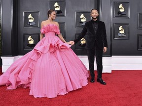 FILE - Chrissy Teigen, left, and John Legend arrive at the 64th Annual Grammy Awards at the MGM Grand Garden Arena on April 3, 2022, in Las Vegas. Chrissy Teigen and her husband John Legend are expecting another child nearly two years after the couple suffered a pregnancy loss. Teigen made the announcement Wednesday, Aug. 3, 2022, on Instagram where she posted two photos of her baby bump.