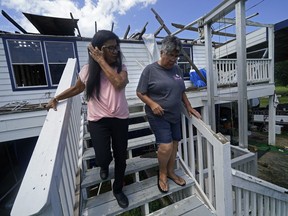 FILE - Louise Billiot, left, a member of the United Houma Nation Indian tribe, walks around the home of her friend and tribal member Irene Verdin, which was heavily damaged from Hurricane Ida nine months before, along Bayou Pointe-au-Chien, in Pointe-aux-Chenes, La., on May 26, 2022. The Federal Emergency Management Agency has developed a singular plan to engage more fully with hundreds of Native American tribes who continue to face climate change-related disasters, the agency announced Thursday, Aug. 18.
