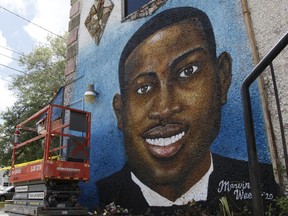 FILE - A recently painted mural of Ahmaud Arbery is displayed in Brunswick, Ga., on May 17, 2020, where the 25-year-old man was shot and killed in February. Months after they were sentenced to life in prison for murder, the three white men who chased and killed Ahmaud Arbery in a Georgia neighborhood faced a second round of criminal penalties Monday, Aug. 8, 2022, for federal hate crimes committed in the deadly pursuit of the 25-year-old Black man.