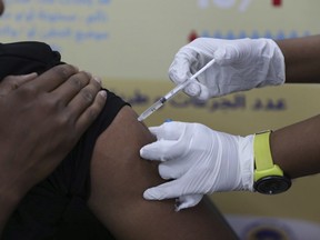 FILE - A man receives the AstraZeneca COVID-19 vaccine at Jabra Hospital in Khartoum, Sudan, Thursday, March 11, 2021. A new philanthropic project hopes to invest $100 million in up to 10 countries mostly in Africa by 2030 to support up to 200,000 community health workers.