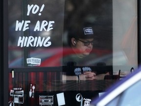 FILE - A hiring sign is displayed at a restaurant in Schaumburg, Ill., Friday, April 1, 2022. More Americans applied for jobless benefits last week, reported Thursday, Aug. 4, 2022, as the number of unemployed continues to rise modestly, though the labor market remains one of the strongest parts of the U.S. economy.