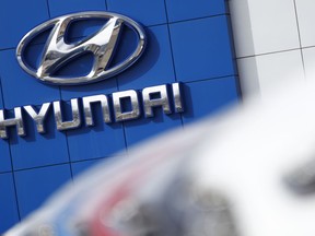 FILE- In this April 15, 2018, file photo, the company logo hangs on the side of a showroom at a Hyundai dealer in Littleton, Colo. The National Highway Traffic Safety Administration's Office of Defects Investigation has opened a query into seat belt pretensioners on certain 2020-2022 Kia/Hyundai vehicles, saying that they may rupture or explode. A seat belt pretensioner is a part of the seat belt system that locks the seat belt in place during a crash.