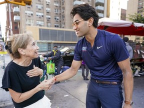 Attorney Suraj Patel, right, speaks to a voter while campaigning, Tuesday, Aug. 16, 2022, in the Upper East Side neighborhood of Manhattan in New York. Patel is running against Rep. Carolyn Maloney and Rep. Jerry Nadler in New York's 12th Congressional District Democratic primary which will be held on Tuesday, Aug. 23, 2022.