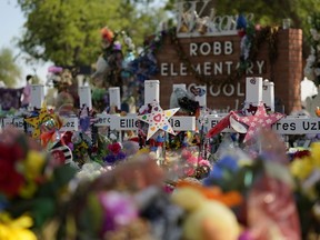 FILE - Crosses, flowers and other memorabilia form a make-shift memorial for the victims of the shootings at Robb Elementary School in Uvalde, Texas, July 10, 2022. The Associated Press and other news organizations are suing officials in Uvalde after months of refusal to publicly release records related to the May 2022 shooting at the elementary school.