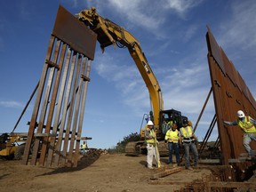 FILE - Construction crews install new border wall sections seen from Tijuana, Mexico., Jan. 9, 2019. An anti-immigration group scored a legal victory on Friday, Aug. 12, 2022, in its federal lawsuit arguing the Biden administration violated environmental law when it halted construction of the U.S. southern border wall and sought to undo other immigration policies by former President Donald Trump.