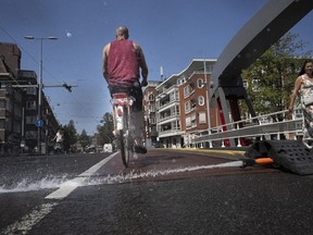As the Dutch capital baked in the heat, municipal workers sprayed water on bridges over the city's canals to prevent metal in the constructions expanding which can jam them shut blocking boat traffic, in Amsterdam, Tuesday, July 19, 2022.