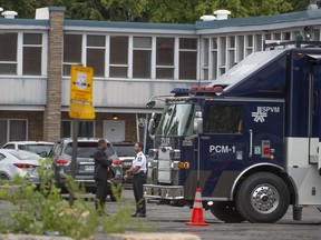 Ermittler der Polizei am Tatort, an dem ein 26-jähriger Mann getötet wurde, nachdem er am frühen Donnerstag, dem 4. August 2022, von der Polizei von Montreal auf dem Parkplatz eines Motels im Stadtteil St-Laurent erschossen worden war.