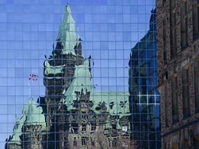 The Confederation Building reflects off the windows of a building in downtown Ottawa on Wednesday, April 7, 2020. The use of facial recognition technology as a security tool on Parliament Hill would pose substantial legal, privacy and human rights risks -- and might even be unlawful, says a study prepared for the parliamentary security unit.
