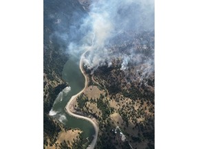 Smoke from a wildfire is visible along Highway 3A at the north end of Yellow Lake in British Columbia in an Aug.3, 2022 handout photo. THE CANADIAN PRESS/HO-BC Wildfire Service **MANDATORY CREDIT**