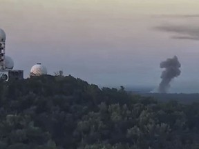 This video still image shows the rising smoke after an explosion at a blasting site inside the Grunewald forest in Berlin, Germany, Thursday, Aug. 4, 2022. A large fire has broke out in one of Berlin's biggest forests triggered by several explosions that took place on a blasting site inside the forest leading to canceled public transportation and the closure of several roads.