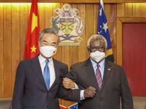 FILE - In this photo released by Xinhua News Agency, Solomon Islands Prime Minister Manasseh Sogavare, right, locks arms with visiting Chinese Foreign Minister Wang Yi in Honiara, Solomon Islands on May 26, 2022. A U.S. coast guard cutter conducting patrols as part of an international mission to prevent illegal fishing was recently unable to get clearance for a scheduled port call in the Solomon Islands, according to reports, an incident that comes amid growing concerns of Chinese influence on the Pacific nation. (Xinhua via AP, File)