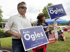 Andy Ogles, left, a candidate in Tennessee's 5th Congressional District Republican primary, campaigns at the entrance to a voting location Thursday, Aug. 4, 2022, in Brentwood, Tenn.