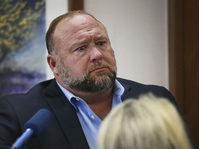 Conspiracy theorist Alex Jones attempts to answer questions about his emails asked by Mark Bankston, lawyer for Neil Heslin and Scarlett Lewis, during trial at the Travis County Courthouse in Austin, Wednesday Aug. 3, 2022. Jones testified Wednesday that he now understands it was irresponsible of him to declare the Sandy Hook Elementary School massacre a hoax and that he now believes it was "100% real."