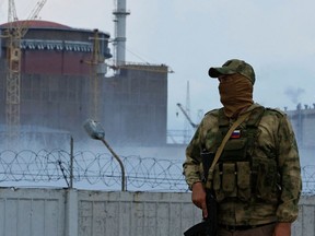 A serviceman with a Russian flag on his uniform stands guard near the Zaporizhzhia Nuclear Power Plant in the course of Ukraine-Russia conflict in the Russian-controlled city of Enerhodar in the Zaporizhzhia region.