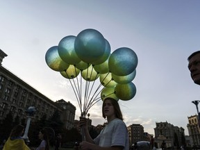 A vendor sells blue and yellow balloons in honor of the country's National Flag Day, Tuesday, Aug. 23, 2022, at Maidan Square in Kyiv, Ukraine. Kyiv authorities have banned mass gatherings in the capital through Thursday for fear of Russian missile attacks. Independence Day, like the six-month mark in the war, falls on Wednesday.
