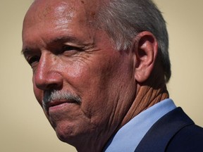 B.C. Premier John Horgan pauses while speaking during a funding announcement for a planned middle-secondary school, in Coquitlam, B.C., on Tuesday, August 30, 2022.