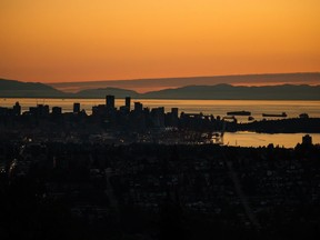 The downtown Vancouver skyline is silhouetted at sunset on July 11, 2022. British Columbia residents are being warned about what Environment Canada calls a "short-lived" heat wave with daytime highs over 30 degrees in several regions, from eastern Vancouver Island to the southern Interior.