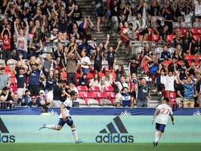 Vancouver Whitecaps' Simon Becher, left, and Ryan Raposo celebrate Becher's tying goal against the Houston Dynamo during the second half of an MLS soccer game in Vancouver, on Friday, August 5, 2022.