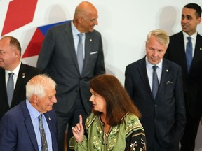 Sweden's Foreign Minister Ann Linde, center, speaks with European Union foreign policy chief Josep Borrell, second left, during a group photo of EU foreign ministers at the Prague Congress Center in Prague, Czech Republic, Wednesday, Aug. 31, 2022. Others from left, Romania's Foreign Minister Bogdan Aurescu, Greek Foreign Minister Nikos Dendias, Finland's Foreign Minister Pekka Haavisto and Italy's Foreign Minister Luigi Di Maio.