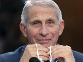 FILE - Dr. Anthony Fauci, Director of the National Institute of Allergy and Infectious Diseases, holds his face mask in his hands as he attends a House Committee on Appropriations subcommittee hearing on about the budget request for the National Institutes of Health, May 11, 2022, on Capitol Hill in Washington. Fauci, the nation's top infectious disease expert who became a household name, and the subject of partisan attacks, during the COVID-19 pandemic, announced Monday he will depart the federal government in December after more than 5 decades of service.