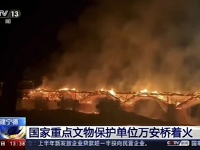 In this image taken from video footage run by China's CCTV, Wan'an Bridge catches fire in Pingnan County in China's Fujian province on Saturday, Aug. 6, 2022. Wan'an Bridge, the longest wooden arch bridge in China with a history of more than 900 years, caught fire and collapsed on Saturday night. (CCTV via AP)