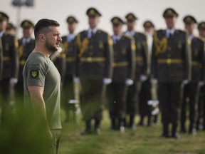 In this photo provided by the Ukrainian Presidential Press Office, Ukrainian President Volodymyr Zelenskyy stands in front of lined up soldiers as he arrives for State Flag Day celebrations in Kyiv, Ukraine, Tuesday, Aug. 23, 2022. (Ukrainian Presidential Press Office via AP)