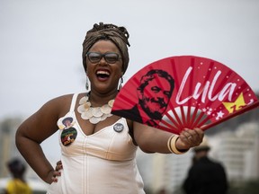 A woman holds a fan with the image of Brazil´s former president Luiz Inacio "Lula" da Silva, who is again running for president, during a Black Women´s March, at Copacabana beach in Rio de Janeiro, Brazil, Sunday, July 31, 2022. Brazil's general elections are scheduled for Oct. 2, 2022.
