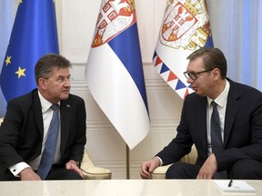In this photo provided by the Serbian Presidential Press Service, Serbian President Aleksandar Vucic, right, speaks with European Union envoy Miroslav Lajcak in Belgrade, Serbia, Thursday, Aug. 25, 2022. Tensions between Serbia and Kosovo soared anew late last month when Kosovo's government declared that Serb-issued identity documents and vehicle license plates would no longer be valid in Kosovo's territory, as Kosovo-issued ones are not valid in Serbia. (Serbian Presidential Press Service via AP)