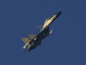 A Chinese J-11 military fighter jet flies above the Taiwan Strait near Pingtan, the closest land of mainland China to the island of Taiwan, in Pingtan in southeastern China's Fujian Province, Friday, Aug. 5, 2022. China says it is canceling or suspending dialogue with the U.S. on issues from climate change to military relations and anti-drug efforts in retaliation for a visit this week to Taiwan by U.S. House Speaker Nancy Pelosi.