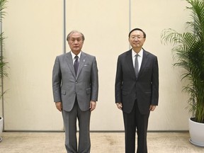 In this photo released by Xinhua News Agency, Yang Jiechi, right, a member of the Political Bureau of the Communist Party of China (CPC) Central Committee and director of the Office of the Foreign Affairs Commission of the CPC Central Committee, poses for photos with Akiba Takeo, head of Japan's National Security Secretariat, during the ninth China-Japan high-level political dialogue in Tianjin municipality in northern China Wednesday, Aug. 17, 2022. Chinese and Japanese officials have met in northern China amid renewed tensions over China's military threats against Taiwan that have prompted protests from Tokyo over the firing of Chinese missiles into Japan's exclusive economic zone.