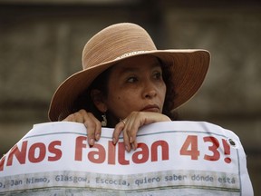 FILE - A woman carries a banner that reads in Spanish "We are missing 43," referring to the 43 missing students from a rural teachers college during a march in Mexico City, Thursday, Nov. 26, 2015. The Truth Commission created to find out what happened to the missing students presented on Thursday, Aug. 18, 2022, a report that hints at the possible responsibility of the Mexican army in the disappearance.