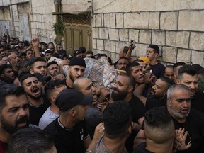 Palestinians carry the body of Islam Sabouh, who was killed during an operation by Israeli forces in the West Bank city of Nablus, Tuesday, Aug. 9, 2022. Israeli police said forces encircled the home of Ibrahim al-Nabulsi, who they say was wanted for a string of shootings in the West Bank earlier this year. They said al-Nabulsi and another Palestinian militant were killed in a shootout at the scene, and that troops found arms and explosives in his home.