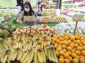 FILE - Customers buy fruit at a stall in Taipei, Taiwan, Sept. 20, 2021. China has blocked imports of citrus and fish from Taiwan in retaliation for a visit to the self-ruled island by a top American lawmaker but avoided sanctions on Taiwanese processor chips for Chinese assemblers of smartphones and other electronics, a step that would send shockwaves through the global economy.