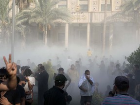 Iraqi security forces fire tear gas on followers of Shiite cleric Muqtada al-Sadr protesting inside the government palace grounds, in Baghdad, Iraq, Monday, Aug. 29, 2022. Al-Sadr, a hugely influential Shiite cleric announced he will resign from Iraqi politics and his angry followers stormed the government palace in response. The chaos Monday sparked fears that violence could erupt in a country already beset by its worst political crisis in years.