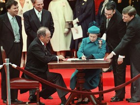 The Queen signs Canada's constitutional proclamation in Ottawa on April 17, 1982 as Prime Minister Pierre Trudeau looks on. THE CANADIAN PRESS/Ron Poling