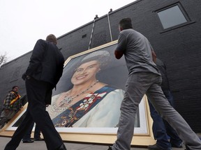 A giant portrait of Queen Elizabeth II is raised outside a local restaurant in Winnipeg, Thursday, Oct. 20, 2016. The painting that was once a fixture during hockey games and concerts in Winnipeg may soon be on public display again.