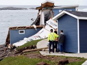 Port aux Basques Mayor Brian Button speaks with two people whose house were damaged after the arrival of Hurricane Fiona in Port Aux Basques, Newfoundland, Canada September 25, 2022.