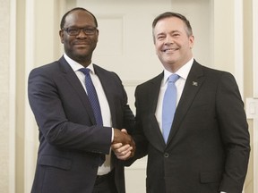 Alberta Premier Jason Kenney shakes hands with Kaycee Madu, in Edmonton on Tuesday, April 30, 2019. The premier is declining to weigh in on one of his cabinet ministers lauding protesters and "freedom convoys" fighting COVID-19 restrictions.