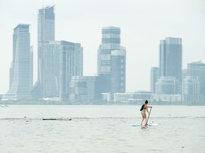 A women paddle boards along Lake Ontario in the extreme heat in Toronto on Friday, July 19, 2019.