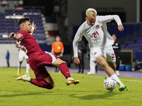 Qatar's Alrawi, left, tries to stop Canada's Liam Millar during the international friendly soccer match between Qatar and Canada, at the Viola Park stadium in Vienna, Austria, Friday, Sept. 23, 2022.&ampnbsp;Early goals by Cyle Larin and Jonathan David helped Canada to a comfortable 2-0 victory over World Cup host Qatar in an international men's soccer friendly Friday.