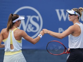 Luisa Stefani, left, of Brazil, bump fists with Gabriela Dabrowski, of Canada during a women's doubles match against Shuko Aoyama and Ena Shibahara, of Japan, at the Western & Southern Open tennis tournament Thursday, Aug. 19, 2021, in Mason, Ohio.&ampnbsp;Dabrowski and her partner Stefani captured their second women's doubles tennis title, winning the Chennai Open on Sunday.