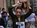 Nasibe Samsaei, eine in der Türkei lebende Iranerin, schneidet sich während eines Protestes vor dem iranischen Konsulat in Istanbul am 21. September 2022 ihren Pferdeschwanz ab, nachdem eine Iranerin nach ihrer Verhaftung durch die Sittenpolizei des Landes in Teheran gestorben ist.