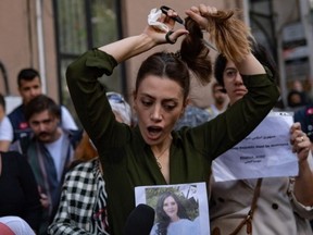 Nasibe Samsaei, an Iranian woman living in Turkey, cuts her ponytail off during a protest outside the Iranian consulate in Istanbul on September 21, 2022, following the death of an Iranian woman after her arrest by the country's morality police in Tehran.