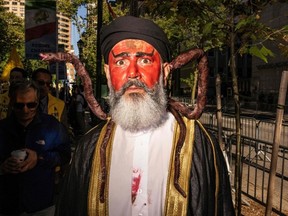 A person dressed as Iranian President Ebrahim Rasi covered in blood with snakes on his shoulders participates in a protest against Iranian President Ebrahim Raisi during a rally in New York City on September 21, 2022, amid the 77th session of the United Nations General Assembly.