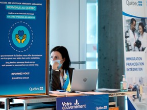 People man a booth at Pierre Elliott Trudeau airport to greet potential Ukrainian refugees, in Montreal on April 6.