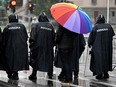 An LGBT activist holds a rainbow umbrella behind police officers during a Pride march in Belgrade, on Sept. 17.